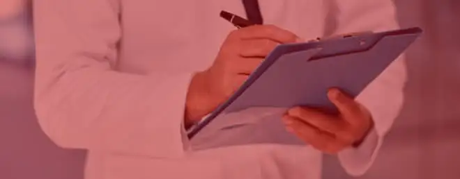 A person in a white coat holds a blue clipboard and pen, writing notes. The image is tinted in red.