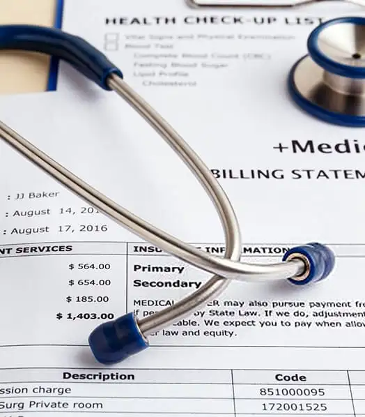 A stethoscope rests on a medical billing statement. The statement lists charges totaling $1,403.00, with amounts under patient services. A health check-up list is partially visible in the background.